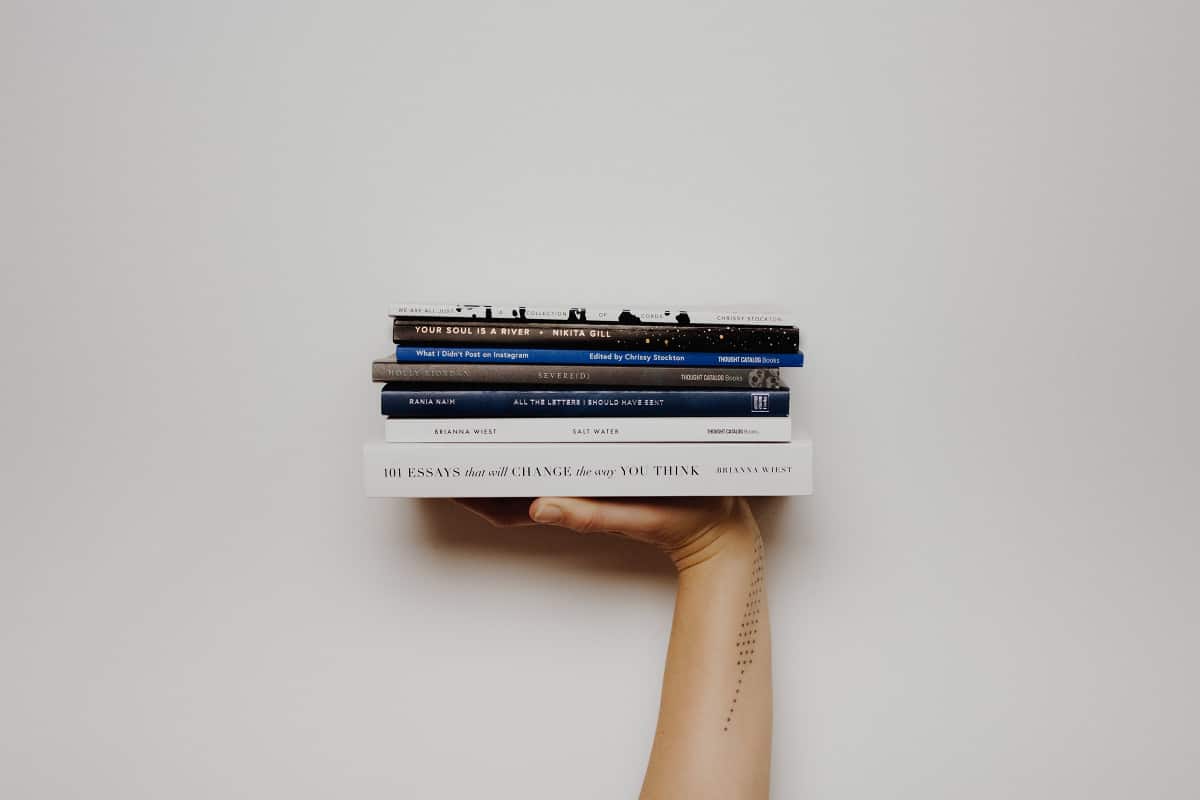 Eine Hand stützt mehre Bücher
